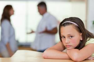 Trauriges Mädchen mit ihren kämpfenden Eltern hinter ihr